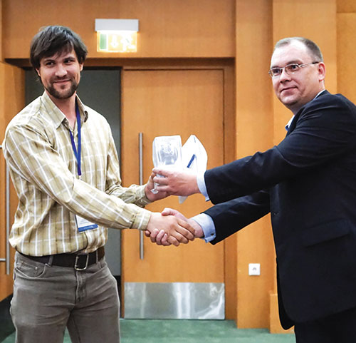 Максим Бадаев (справа), руководитель проекта, ЗАО «Нанософт», вручает подарок от спонсора конференции